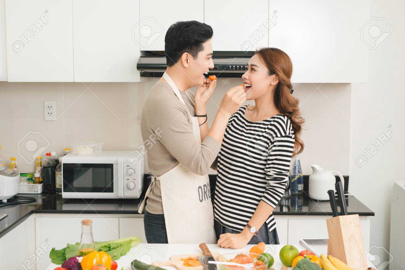 loving-vietnamese-couple-cooking-together-in-the-kitchen-at-home