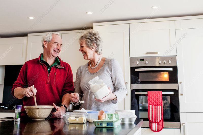 Senior couple baking together in kitchen