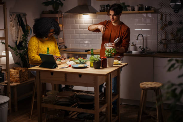 Happy young couple preparing homemade pizza for Christmas dinner at home. Multiracial couple spending time together at home, preparing dinner