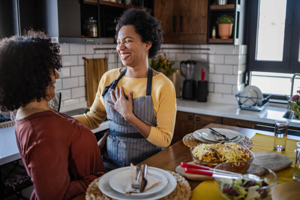 Portrait of two women enjoying lunch at home. They are having fun in the dining room.